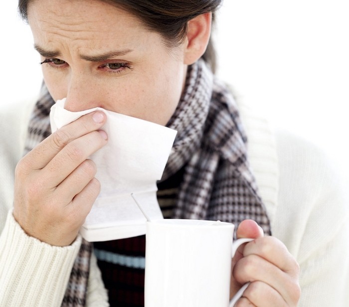 Woman Holding a Mug with a Handkerchief to Her Nose